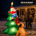 Dog pulling Santa's pants inflatable glowing in a front yard at night