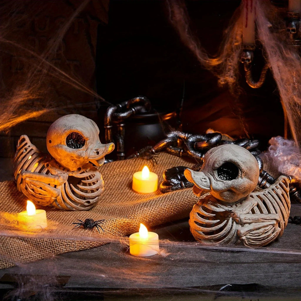 Skeleton ducks in an indoor Halloween tabletop display with candles and spider webs
